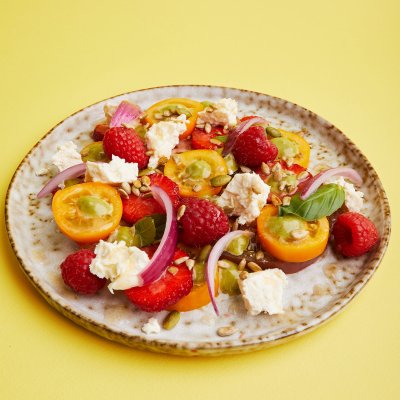 Разноцветные томаты с ягодами, молодым сыром и соусом из базилика и тархуна
